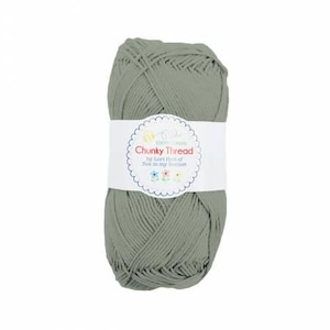 May include: A ball of sage green chunky thread with a white label wrapped around it. The label reads "Chunky Thread" in red text, with the words "by Lori Holt of Bee in my Bonnet" below. The label has a scalloped edge and floral accents.