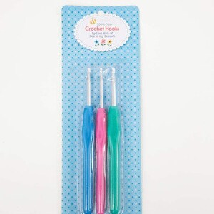 May include: A package of three crochet hooks, one blue, one pink, and one green. The package is labeled "100% Cotton Crochet Hooks by Lori Holt of Bee in My Bonnet."