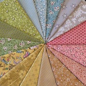 May include: A circular arrangement of fabric swatches in various colors and patterns. The fabrics include floral, paisley, and geometric designs in shades of green, blue, pink, yellow, and brown. The swatches are arranged like a fan.