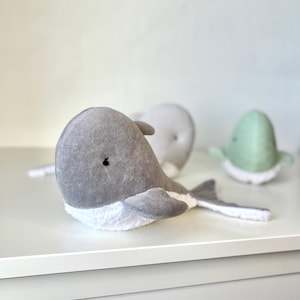 以下が含まれることがあります： 白いセラミックマグカップ、黒いハンドル、手書き風の「But First, Coffee」の文字。マグカップは白い表面に置かれています。マグカップの高さは10cmです。