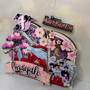 Pode incluir: Topper de bolo em camadas com tema Inuyasha com flores de cerejeira rosa, o n&uacute;mero 1 e o nome "Andayah". O logotipo Inuyasha &eacute; vis&iacute;vel. O design apresenta personagens da s&eacute;rie de anime.