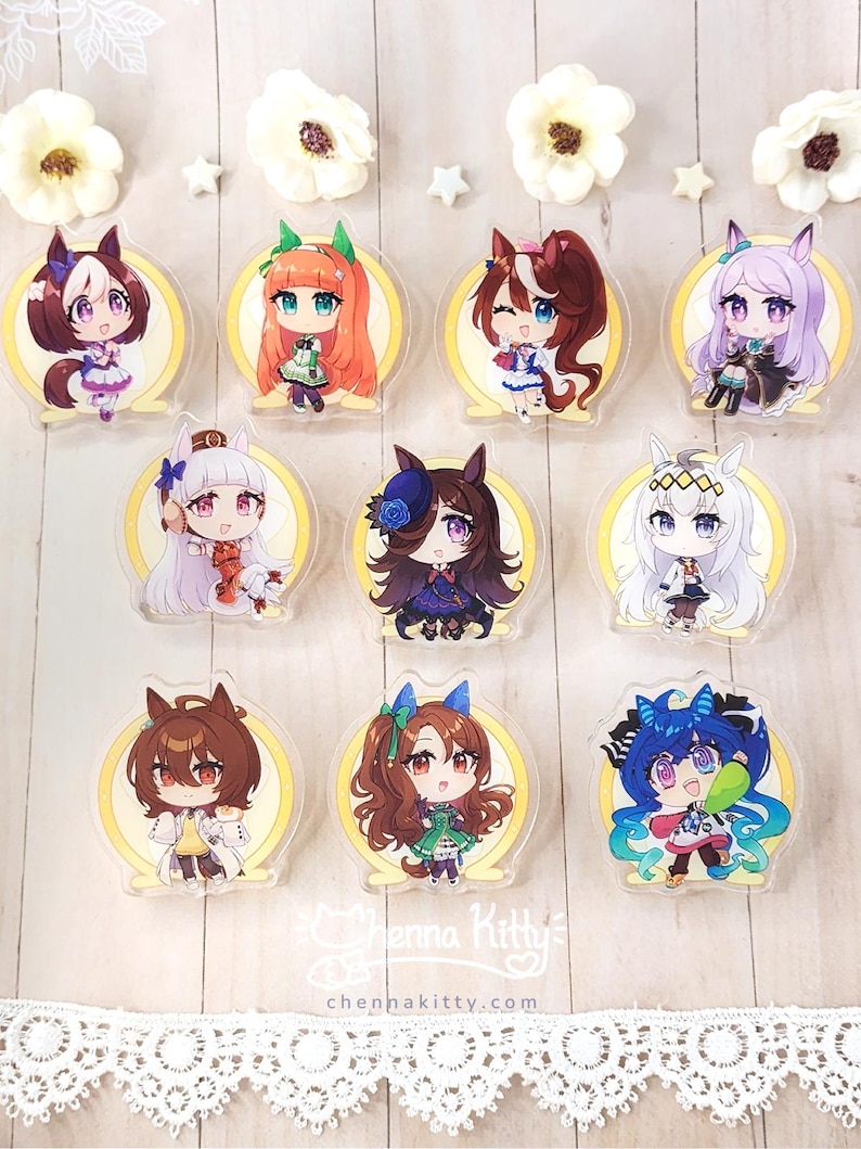 May include: A collection of nine acrylic charms featuring chibi-style anime characters with animal ears, each set against a circular yellow background. The charms display various hair colors and outfits. Text at the bottom reads Chenna Kitty.