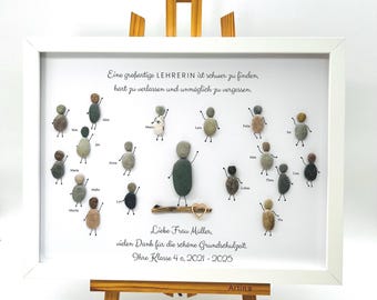 May include: A framed artwork with a white background and a message about a teacher. The artwork features a group of small figures made of stones, each with a name written next to it. The message reads: "A great teacher is hard to find, hard to leave and impossible to forget." The artwork also includes the text: "Liebe Frau Müller, vielen Dank für die schöne Grundschulzeit. Ihre Klasse 4 c, 2021-2025."