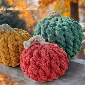 Puede incluir: Tres calabazas de felpa hechas a mano en colores oto&ntilde;ales: dorado, rojo y verde. Cada calabaza tiene un aspecto de punto grueso y texturizado y un tallo de color crema. Las calabazas est&aacute;n dispuestas sobre una superficie de madera con un fondo oto&ntilde;al borroso.