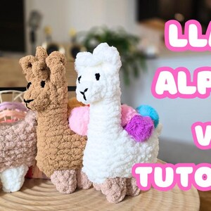 May include: Three crocheted llama and alpaca plush toys in pink, brown, and white. The toys are sitting on a wooden surface. The text "LLAMA ALPACA VIDEO TUTORIAL" is in pink letters on a white background.