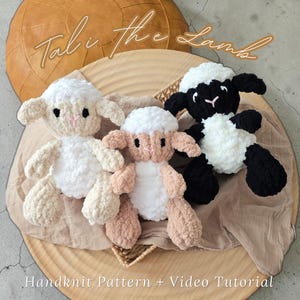 Puede incluir: Tres peluches de cordero tejidos a mano en blanco, crema y negro, con detalles en rosa. Los corderos están colocados sobre una bandeja de madera con un paño beige. El texto "Tali the Lamb" y "Handknit Pattern + Video Tutorial" son visibles.