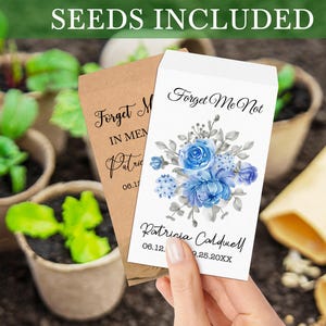 May include: Two seed packets with forget-me-not flower seeds. The packets are brown and white with blue watercolor flowers and the text "Forget Me Not" and "Patricia Caldwell 06.12. 9.25.20XX".