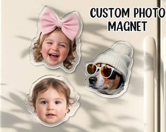 May include: Custom photo magnets featuring a smiling child with a pink bow, a child, and a dog wearing sunglasses and a white beanie. The magnets are clear with a scalloped edge. Text on the image reads "CUSTOM PHOTO MAGNET".