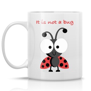 May include: White ceramic mug with a black and red ladybug illustration and the text "It is not a bug".