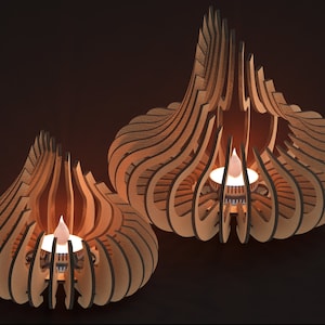 May include: Two wooden candle holders with intricate designs. Each holder features a small, round candle in the center, with the flames glowing brightly.