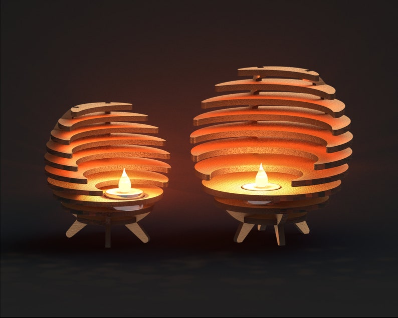 K&ouml;nnte beinhalten: Zwei Kerzenhalter aus Holz mit geometrischem Design. Die Halter sind kugelf&ouml;rmig und haben eine Reihe &uuml;berlappender Ringe. Jeder Halter hat eine kleine Kerze im Inneren, und die Flammen sind sichtbar.