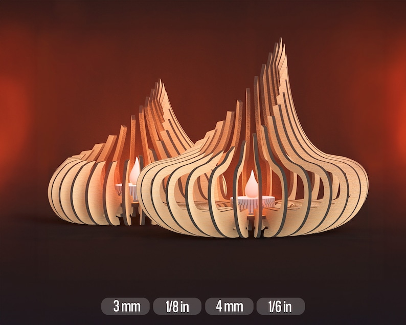 May include: Two wooden candle holders in the shape of a teardrop with intricate cutouts. The holders are made of light brown wood and have a natural finish. The candle holders are 3 mm thick and 1/8 in thick.