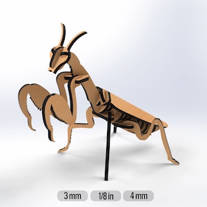 May include: A wooden praying mantis model with black details. The model is assembled and standing on a black stand. The model is approximately 4 inches long.