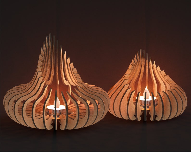 May include: Two wooden candle holders in the shape of a teardrop with intricate cutouts. The candle holders are lit with small tea lights.