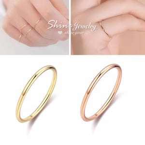 May include: Gold and rose gold thin band rings. The rings are shown on fingers and isolated on a white background. The rings are simple and elegant. The text "Shine Jewelry" is in the image.