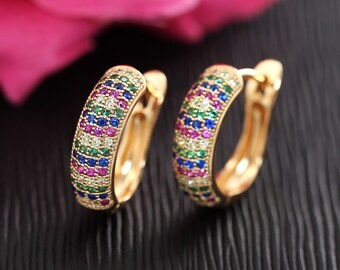 May include: A pair of gold hoop earrings with a colorful, multi-colored, pave setting of small round stones. The stones are set in a continuous pattern around the hoop.