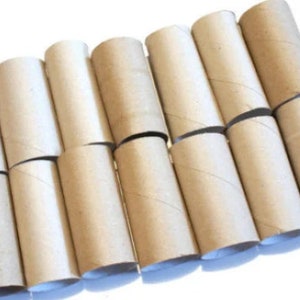 Peut inclure: Une collection de tubes en carton vides, probablement issus de rouleaux de papier toilette ou d'essuie-tout. Les tubes sont disposés en diagonale, révélant leur forme cylindrique et la couleur marron naturelle du carton.