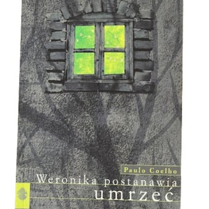 May include: A book cover with a dark grey background and a window with a green glow. The title of the book is "Veronika Decides to Die" by Paulo Coelho.