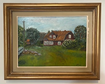 May include: Oil painting of a rural landscape featuring a red-roofed house with white-framed windows, surrounded by green trees and grass. The artwork is framed in a gold-colored wooden frame.
