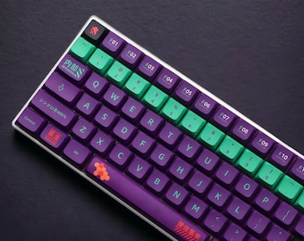 May include: A purple and green mechanical keyboard with a white frame. The keys have different colored keycaps, including green, purple, and orange. The keyboard has a Japanese layout with the text "内部" and "シンクロ率400%" printed on the keys.