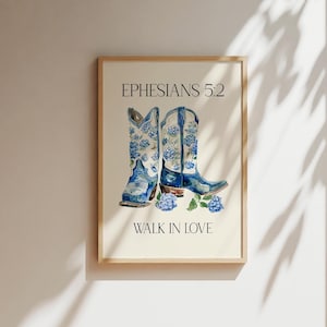 May include: A framed print with a watercolor illustration of two blue cowboy boots with floral designs. The text "Ephesians 5:2 Walk in Love" is printed below the boots.