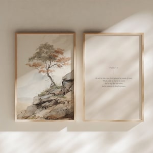Puede incluir: Una pintura de acuarela de un árbol creciendo en un acantilado rocoso. La pintura está enmarcada en un marco de madera claro. El texto "Salmo 1:3" y una cita del versículo bíblico están impresos en un fondo blanco en un marco separado.