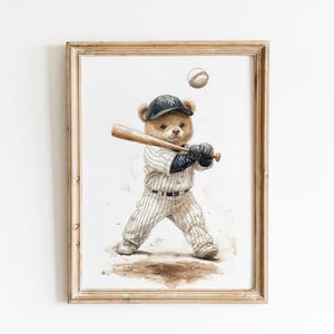 Pode incluir: Impress&atilde;o em aquarela emoldurada de um urso de pel&uacute;cia com uniforme de beisebol, pronto para rebater. O urso usa um bon&eacute; azul marinho com o logotipo "NY" branco, um uniforme listrado e luvas pretas. Uma bola de beisebol est&aacute; no ar. A moldura &eacute; de madeira marrom claro.