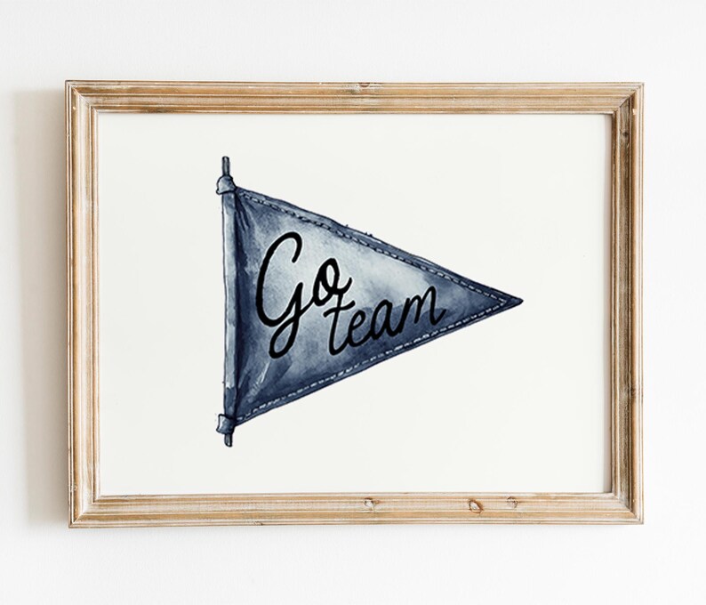 Pode incluir: Impress&atilde;o em aquarela de uma bandeira de bandeirola azul com as palavras "Go team" em escrita preta. A bandeira &eacute; emoldurada em uma moldura de madeira marrom clara, em um fundo branco. Uma pe&ccedil;a decorativa para um f&atilde; de esportes.