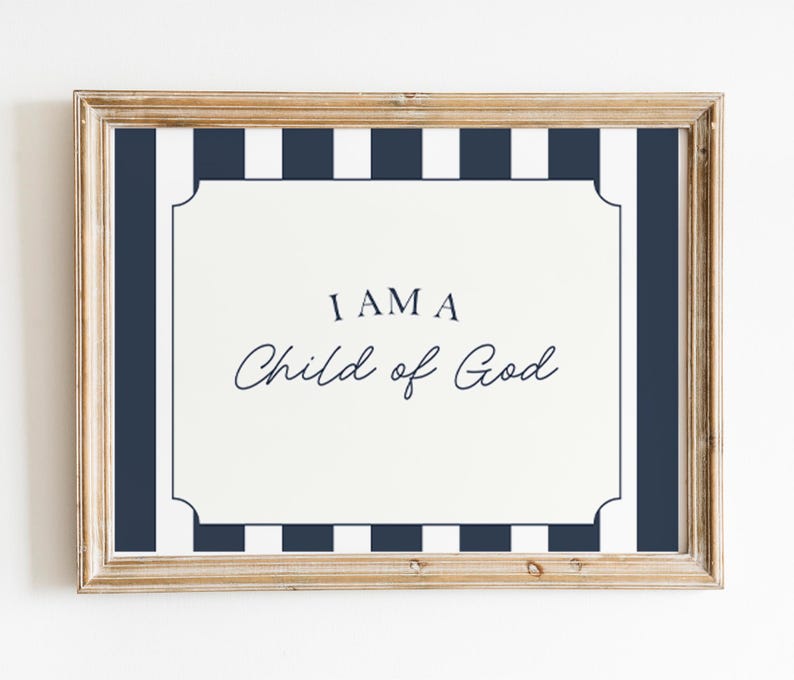 Pode incluir: Uma impress&atilde;o emoldurada com o texto "I AM A Child of God" em uma fonte decorativa. A impress&atilde;o tem um fundo branco com uma borda listrada azul marinho e branca e uma moldura dourada.