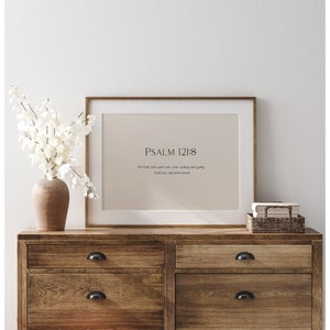 May include: A framed print with a beige background and the text "PSALM 121:8" and the quote "The lord will watch over your coming and going both now and forevermore".