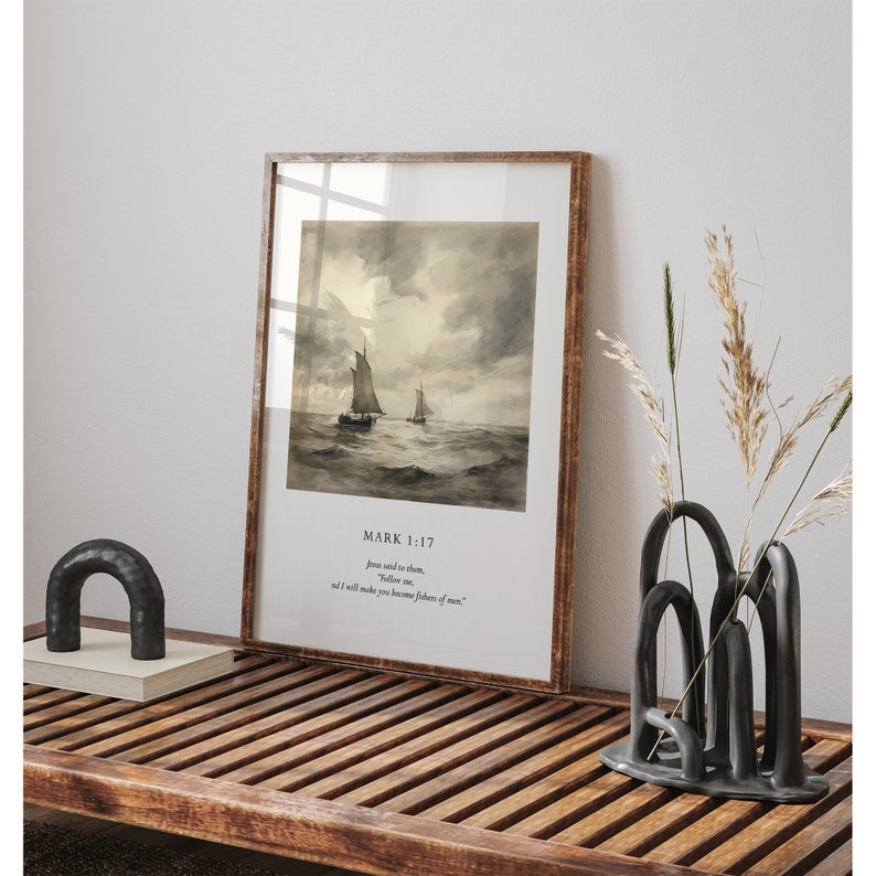 May include: A framed print with a watercolor painting of two sailboats on the sea. The print has a white border and a brown frame. The text "MARK 1:17" is printed below the image, followed by a quote from the Bible: "Jesus said to them, "Follow me, and I will make you become fishers of men."