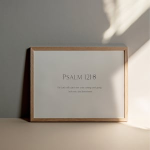 May include: A framed print with a light wood frame and a white background. The print features the text "PSALM 121:8" and the verse "The Lord will watch over your coming and going both now and forevermore."