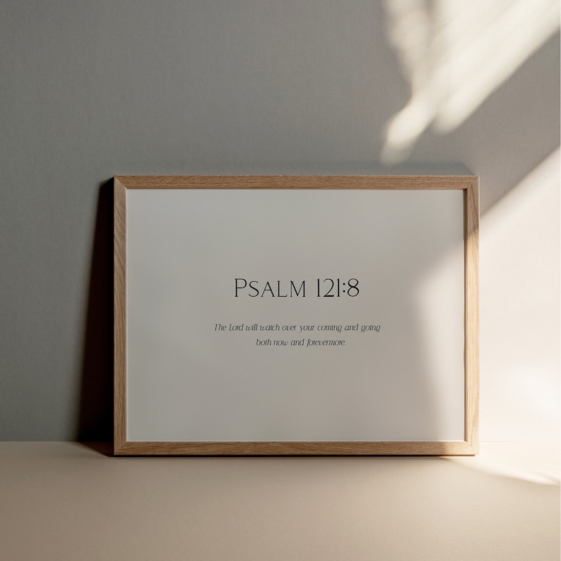 May include: A framed print with a light wood frame and a white background. The print features the text "PSALM 121:8" and the verse "The Lord will watch over your coming and going both now and forevermore."