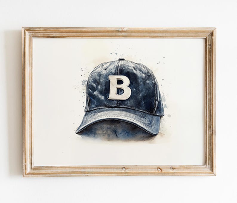 Pode incluir: Pintura em aquarela de um bon&eacute; de beisebol azul com um "B" branco na frente. A obra de arte &eacute; emoldurada em uma moldura de madeira clara. O fundo tem respingos de aquarela azul.