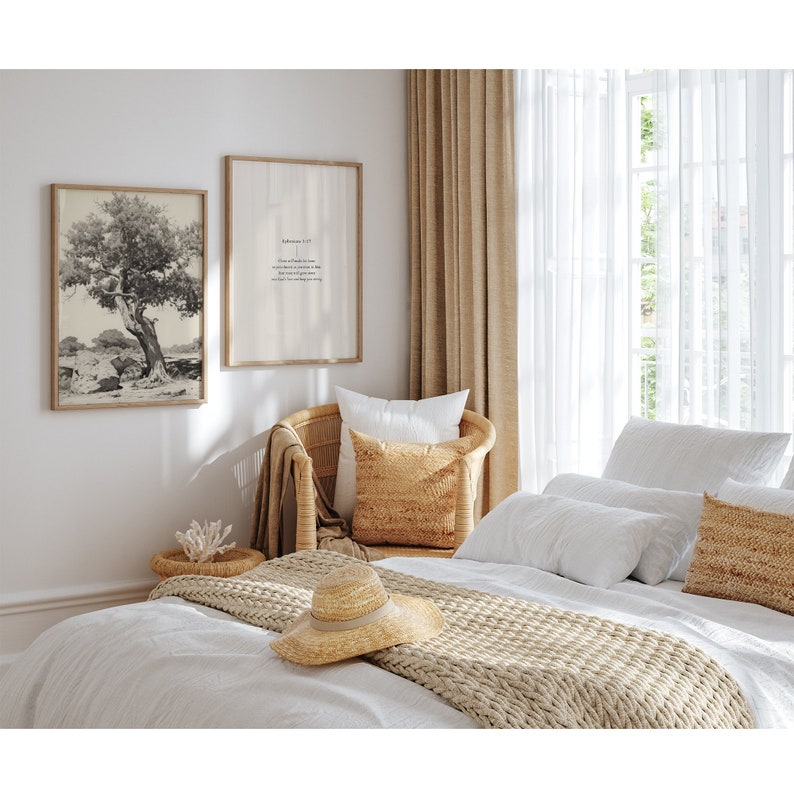 Pode incluir: Uma cama branca com uma manta de malha bege e um chap&eacute;u de palha. A cama est&aacute; em um quarto com paredes brancas, uma cadeira de vime com uma almofada bege e duas impress&otilde;es emolduradas na parede. Uma impress&atilde;o &eacute; uma foto em preto e branco de uma &aacute;rvore, e a outra impress&atilde;o tem uma cita&ccedil;&atilde;o da B&iacute;blia.