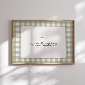 May include: A framed print with a green and white gingham border. The print features the Bible verse Philippians 4:13, "I can do all things through Christ who strengthens me."