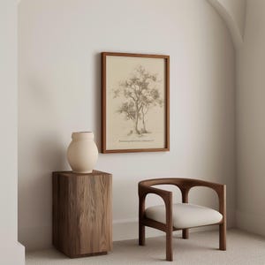Puede incluir: Una impresi&oacute;n enmarcada de un dibujo a l&aacute;piz de un &aacute;rbol con el texto "Rooted and grounded in love, 1 Corinthians 13:13". La impresi&oacute;n est&aacute; colgada en una pared blanca sobre una mesa auxiliar de madera con un jarr&oacute;n de cer&aacute;mica beige. Una silla de madera con un coj&iacute;n blanco est&aacute; en primer plano.