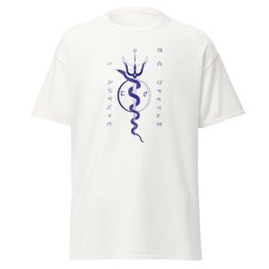 Peut inclure: T-shirt blanc avec un motif graphique bleu. Le motif représente un trident, un croissant de lune, un cercle et un serpent. Il y a du texte des deux côtés du motif. Le t-shirt est fait d'une matière douce.