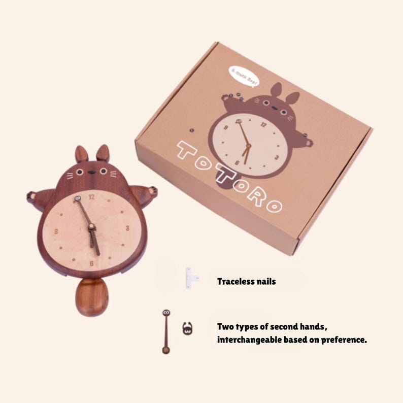 May include: A wooden wall clock shaped like the character Totoro from the movie My Neighbor Totoro. The clock has a brown wooden body and a light wood face with black hands. The clock comes with a box that has the Totoro character on it and the word "TOTORO" printed on the box. The clock also comes with two types of second hands, one with a small Totoro character and one without.