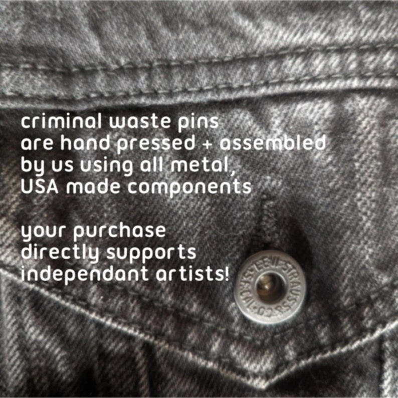 May include: Close-up of a gray denim jacket pocket with a silver button. The text reads: "criminal waste pins are hand pressed + assembled by us using all metal, USA made components. Your purchase directly supports independant artists!"