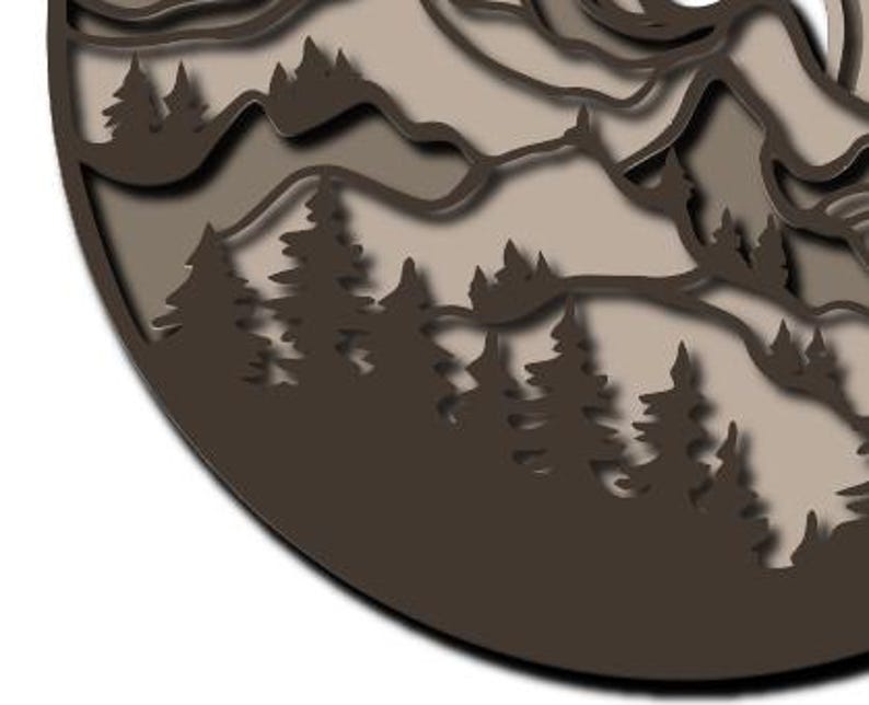 May include: A circular wall art piece featuring a layered, cut-out design of a mountain range and a dense forest of pine trees. The artwork uses varying shades of brown and beige to create depth, with dark brown silhouettes of trees in the foreground.