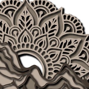 May include: A multi-layered laser-cut wall art piece featuring a beige and dark brown mountain range silhouette at the bottom, topped with an intricate, symmetrical mandala pattern in shades of beige and brown, creating a dimensional effect.