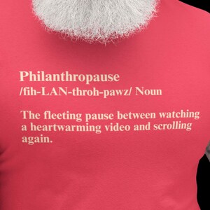 Pode incluir: Camiseta vermelha com a palavra "Philanthropause" em texto branco, junto com sua pronúncia e definição: "A pausa fugaz entre assistir a um vídeo emocionante e rolar novamente."