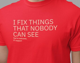 Op de afbeelding: Rood T-shirt met de tekst "I FIX THINGS THAT NOBODY CAN SEE" in witte letters. Daaronder staat "You're welcome, IT support". Het T-shirt heeft een ronde hals.