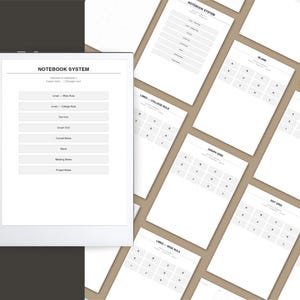 a collection of blank notebooks and planners arranged in a grid-like pattern, with a notebook titled "Notebook System 2" placed on a dark surface.