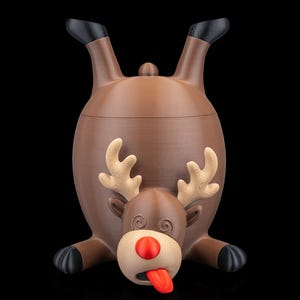 May include: A brown novelty container shaped like a reindeer, with its rear end up and head down. The reindeer has tan antlers, a red nose, and a red tongue sticking out. The container has black hooves and ears.
