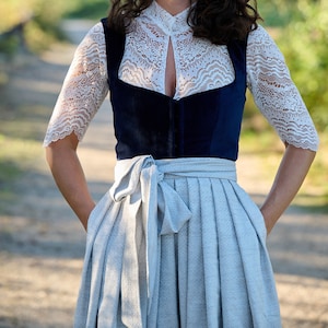 May include: A white lace bodice with a navy blue velvet overlay and a light blue skirt. The bodice has a lace-up front and the skirt is pleated.