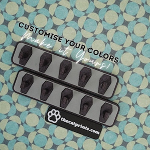 May include: Two gray rectangular hook strips with six black hooks each, against a patterned background. The text "CUSTOMISE YOUR COLORS Make it Yours!" is displayed. A black label with a paw print and thecatprints.com is at the bottom.