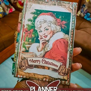 May include: A Retro Christmas journal and ephemera kit with 28 pages. The cover features a vintage illustration of a woman in a Santa hat with the words "Merry Christmas" on a banner. The journal has a butterfly logo that says "Planner".