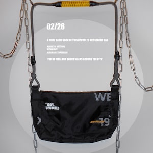 以下が含まれることがあります： 「100% UPCYCLED」と「WE 19」の文字が入った黒いメッセンジャーバッグ。バッグはチェーンと黄色のハンドルが付いた灰色のロープで吊り下げられています。「02/26」の文字も表示されています。